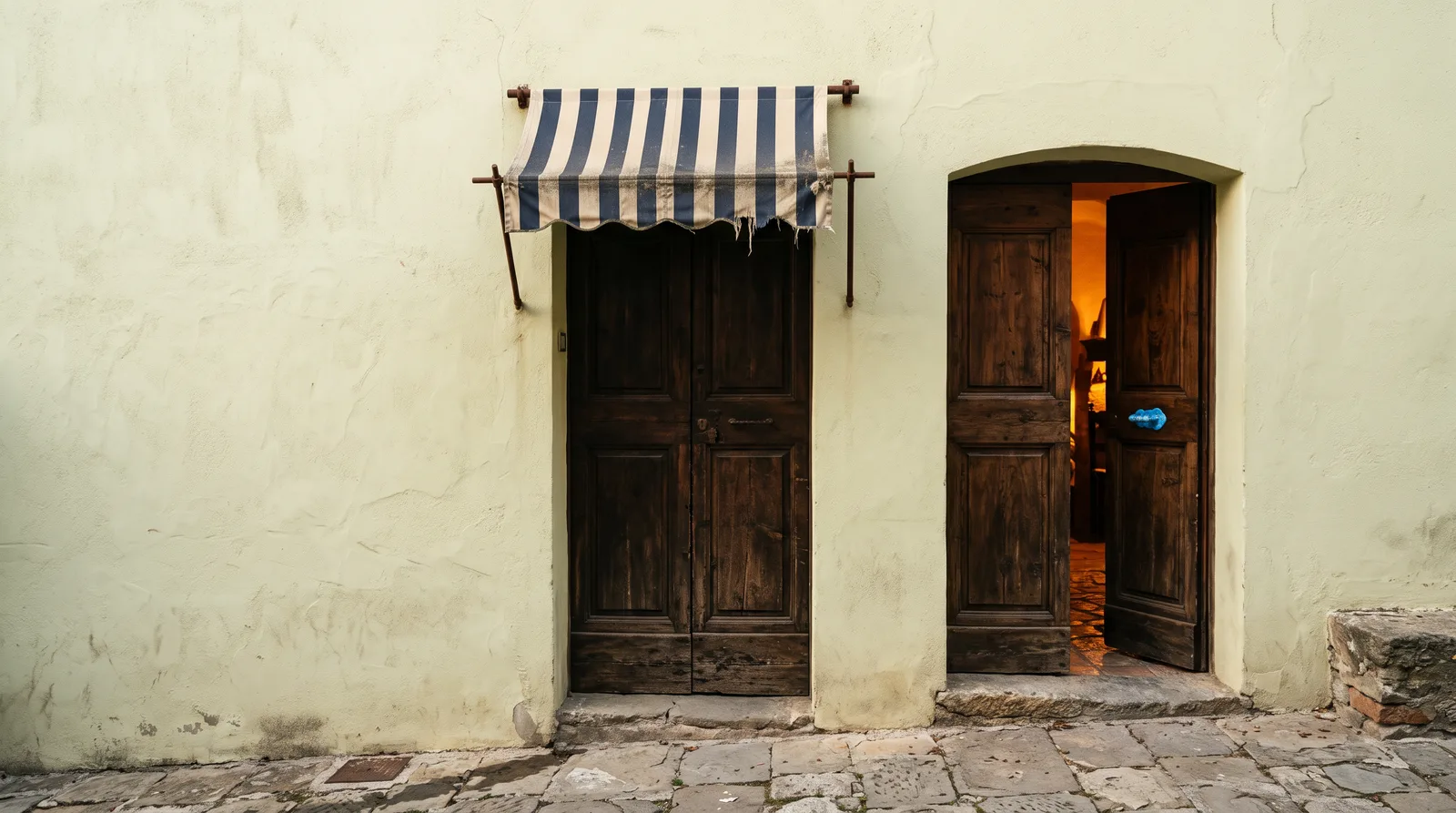 Two wooden doorways side by side, the left under a striped awning banner and the right clean and open, standing in for ad supported and ad free plans